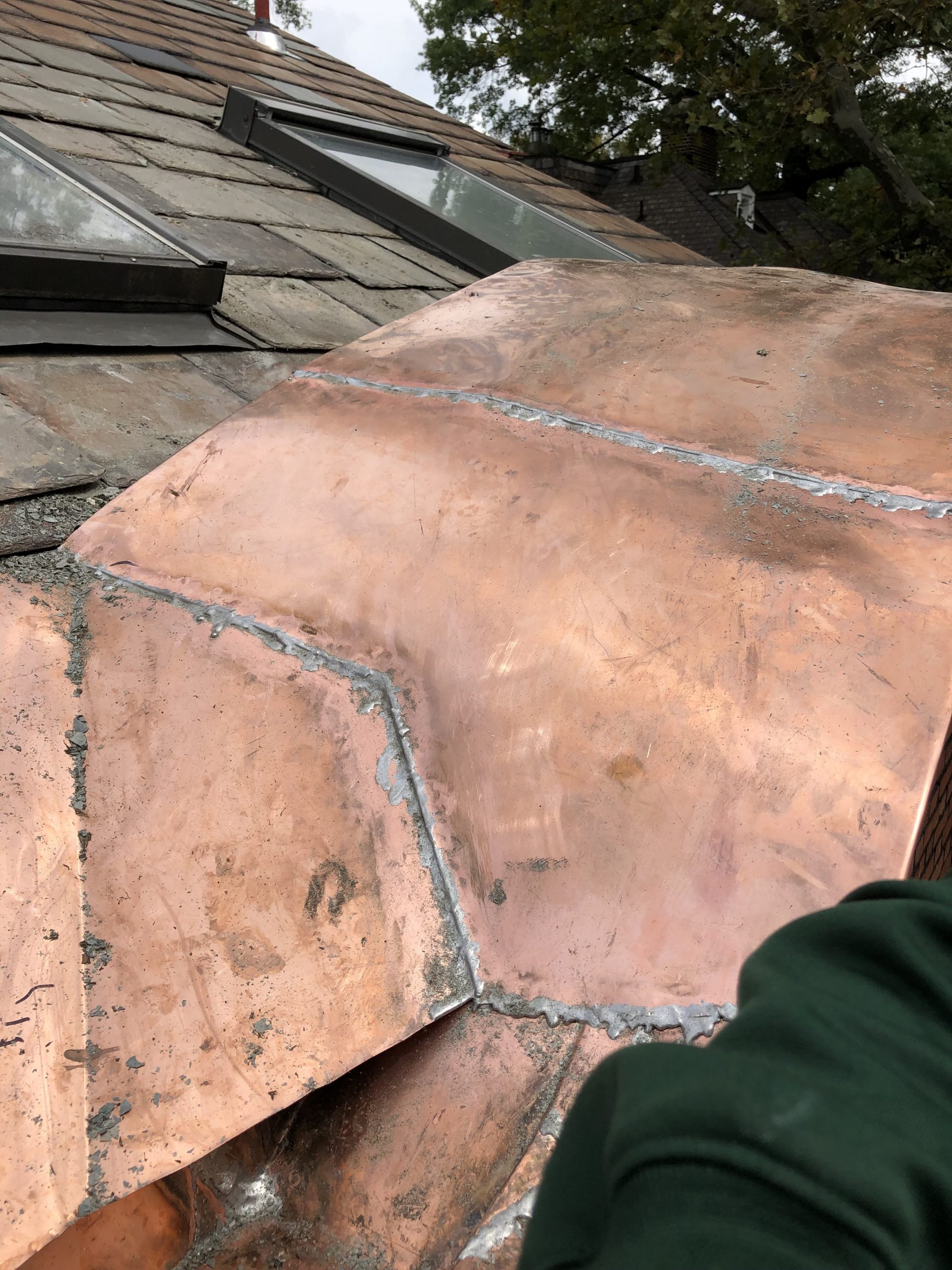 Skylights integrated into a slate roof beside custom copper work